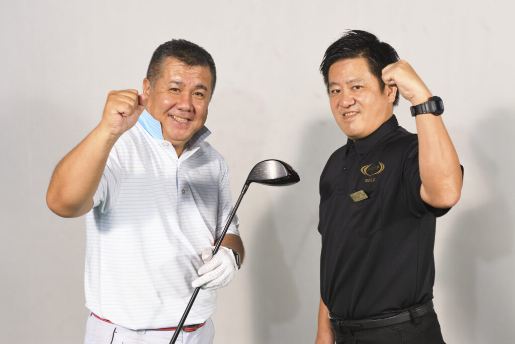 クラブを持つRIZAP GOLFの利用者と専属トレーナー